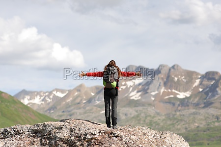 Back view portrait of a hiker celebrating vacation in the top of a high mountain