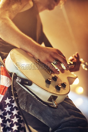 Young man playing guitar at a music festival. This concert was created for the sole purpose of this photo shoot,  featuring 300 models and 3 live bands. All people in this shoot are model released