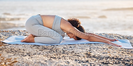 Beach yoga,  fitness and woman stretching down,  kneeling and balance,  childs pose and health. Balasana exercise,  mindfulness and sea workout,  energy and wellness,  zen and pilates,  nature or meditation.