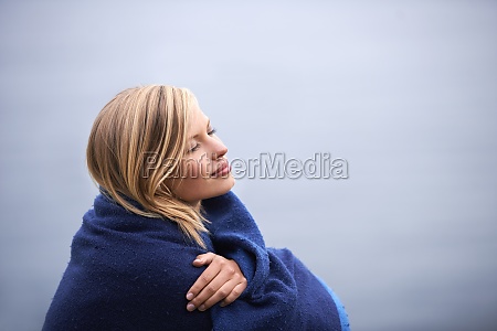 Morning contemplation. a beautiful young woman standing at the ocean