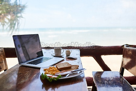 Laptop,  beach or empty table at cafe for remote workspace in the morning with wifi connection. Background,  internet or luxury seaside coffee shop for travel blog online with brunch meal,  tea or food.