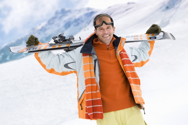 smilende mand holder ski pa bjerget