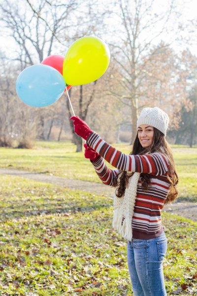 glad ung kvinde med farverige balloner