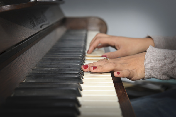 mloda kobieta grajaca na pianinie