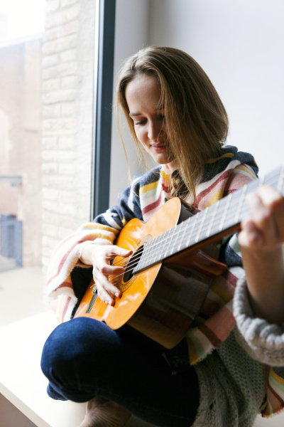 ung kvinde spiller guitar