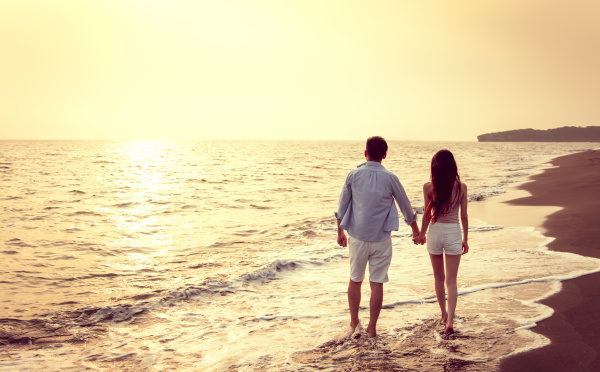 pareja joven caminando en la playa