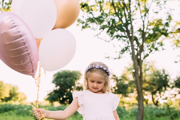 small shiny girl with pink balloons