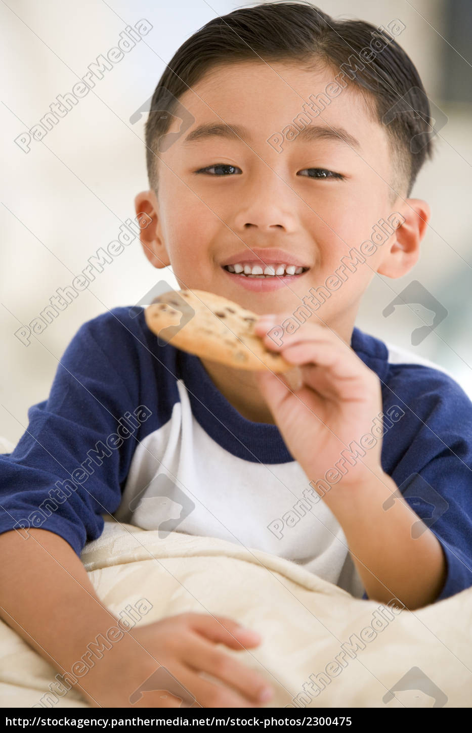 Menino comendo biscoito na sala sorrindo - Stockphoto #2300475 | Banco de  Imagens Panthermedia