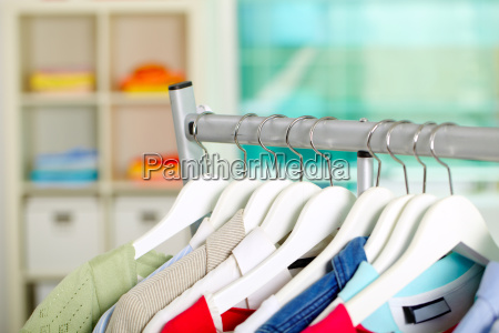 Photo of hangers with different clothes in department