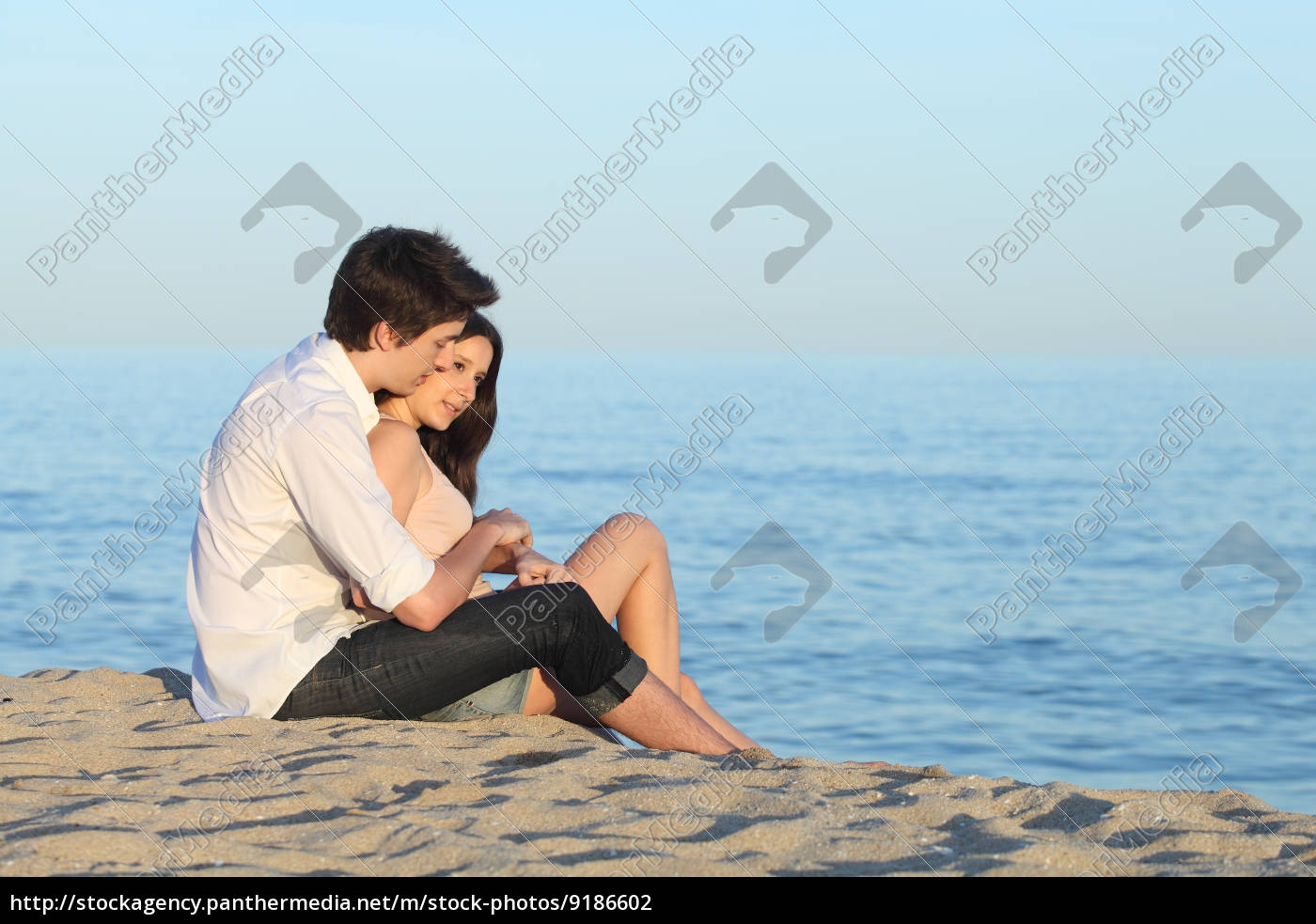 Casal abraçando sentado na areia da praia - Stockphoto #9186602 | Banco de  Imagens Panthermedia