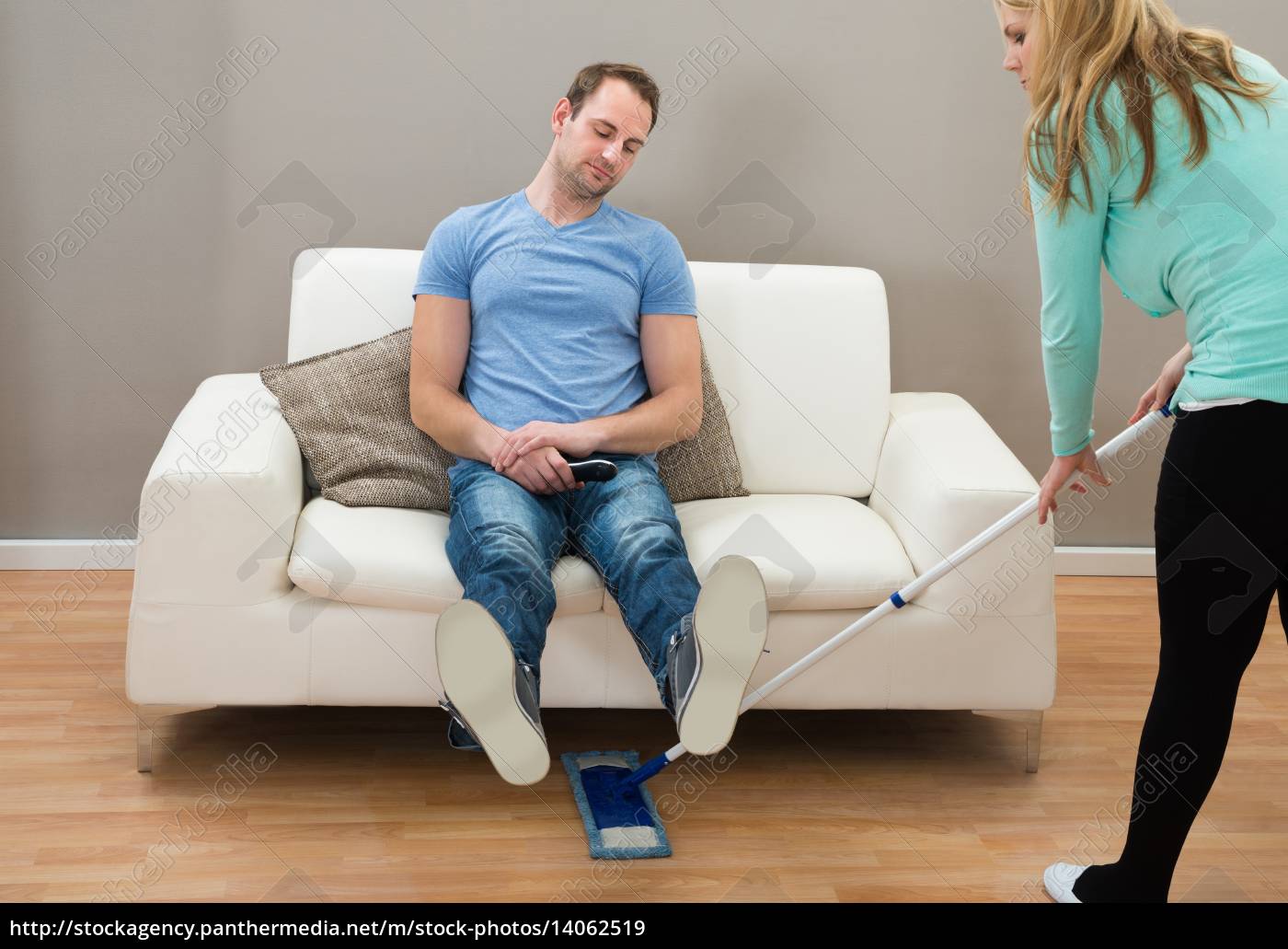 mujer limpiando piso mientras hombre en el sofá - Foto de archivo #14062519  | Agencia de stock PantherMedia