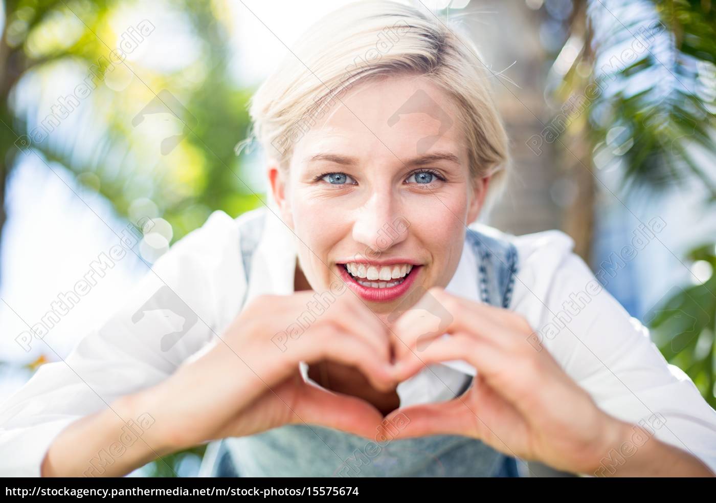 Mulher loira bonita sorrindo para a câmera e fazendo - Stockphoto #15575674  | Banco de Imagens Panthermedia