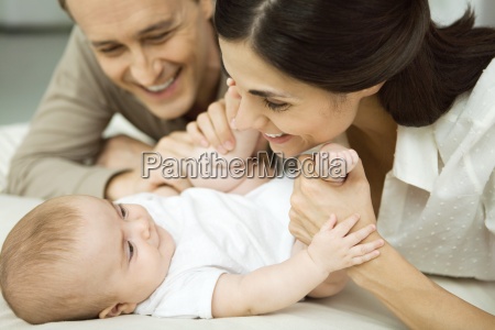 New parents smiling at infant mother holding baby s - Lizenzfreies Bild ...