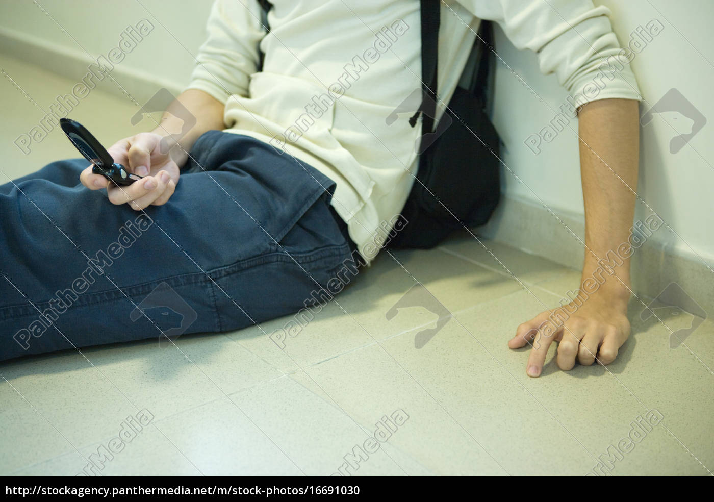 Estudante do sexo masculino sentado no chão segurando - Stockphoto  #16691030 | Banco de Imagens Panthermedia