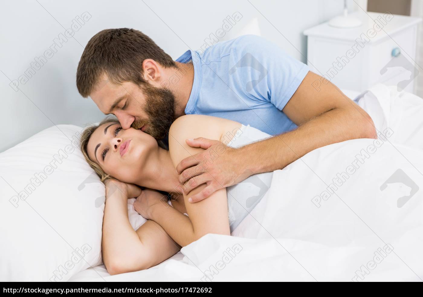 Hombre besando mujer en su mejilla en la cama - Stockphoto #17472692 |  Agencia de stock PantherMedia