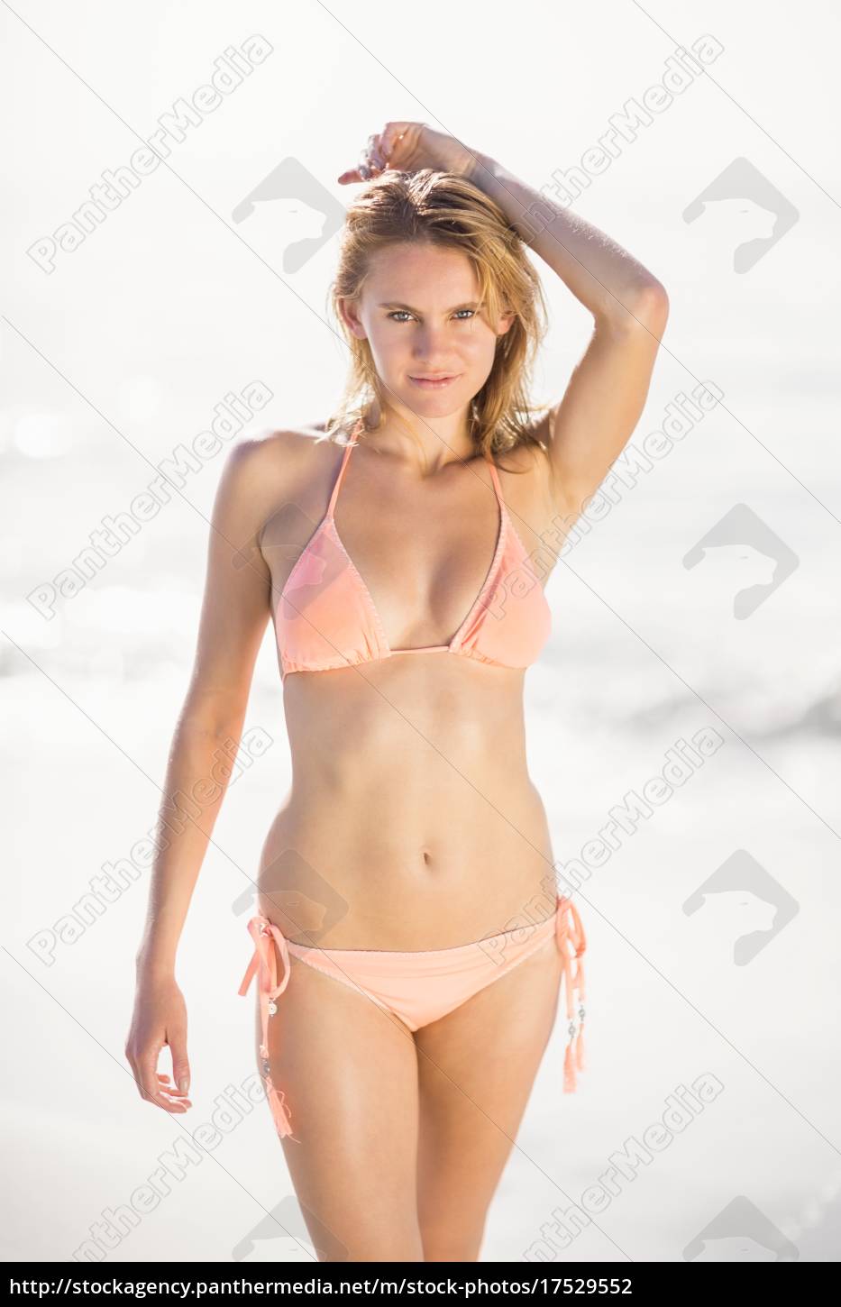 retrato de mujer guapa en bikini de pie en la playa - Stockphoto #17529552  | Agencia de stock PantherMedia