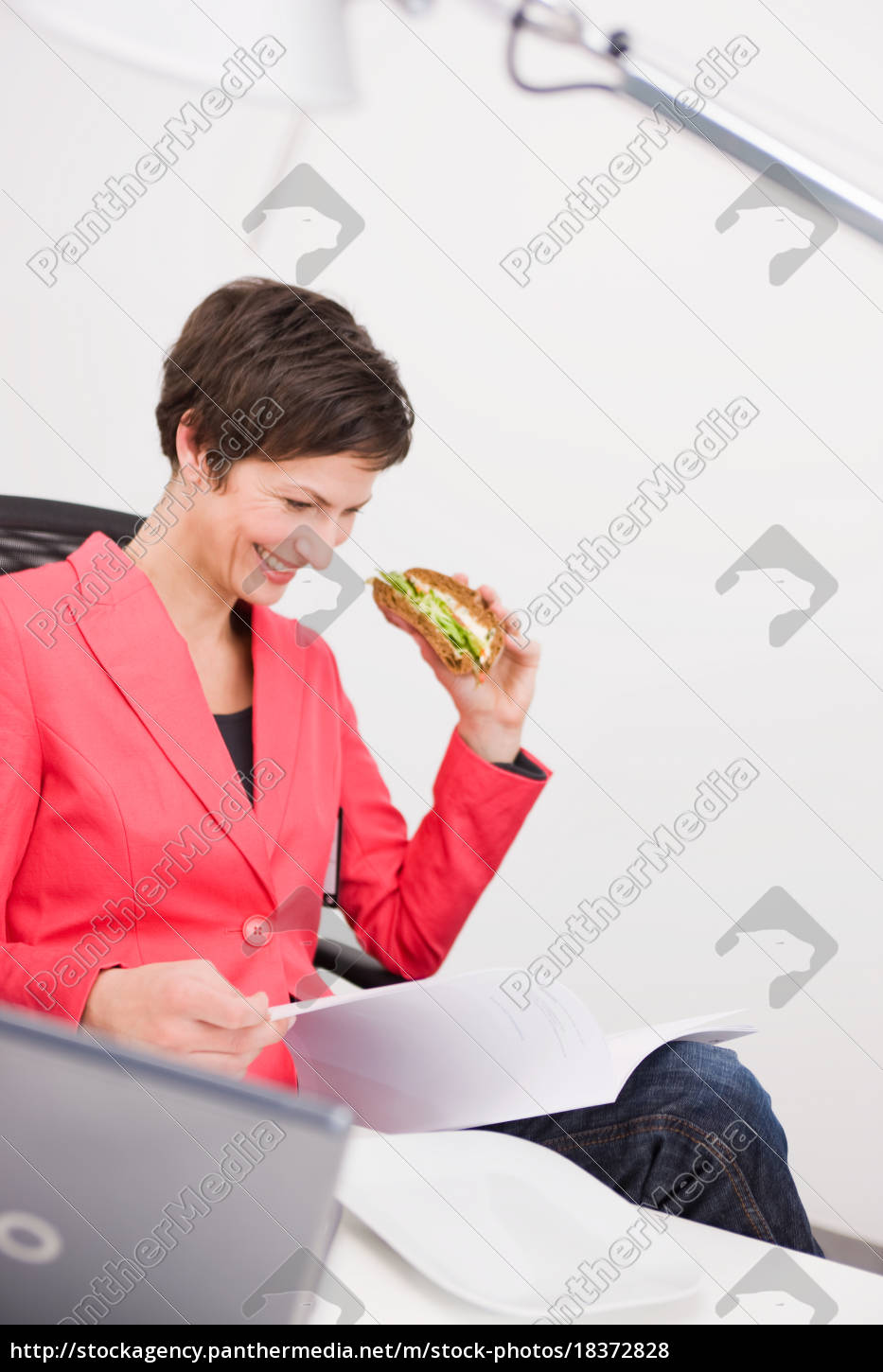 Mulher comendo sanduíche em seu escritório - Stockphoto #18372828 | Banco  de Imagens Panthermedia