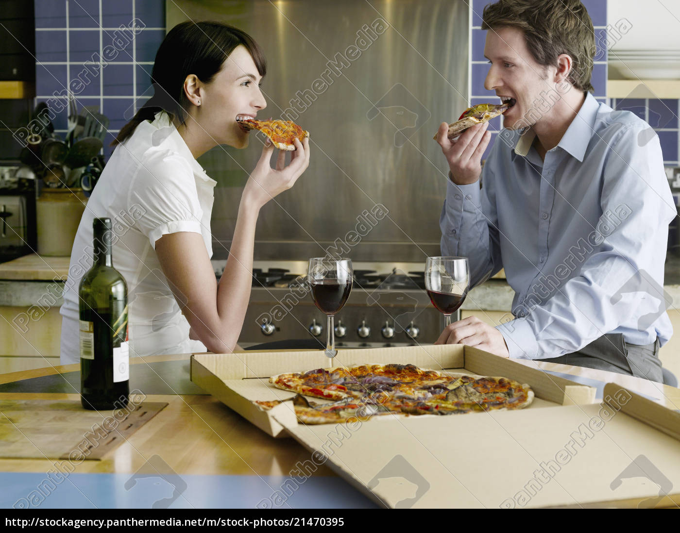 Casal feliz comendo pizza na cozinha - Fotos de arquivo #21470395 | Banco  de Imagens Panthermedia