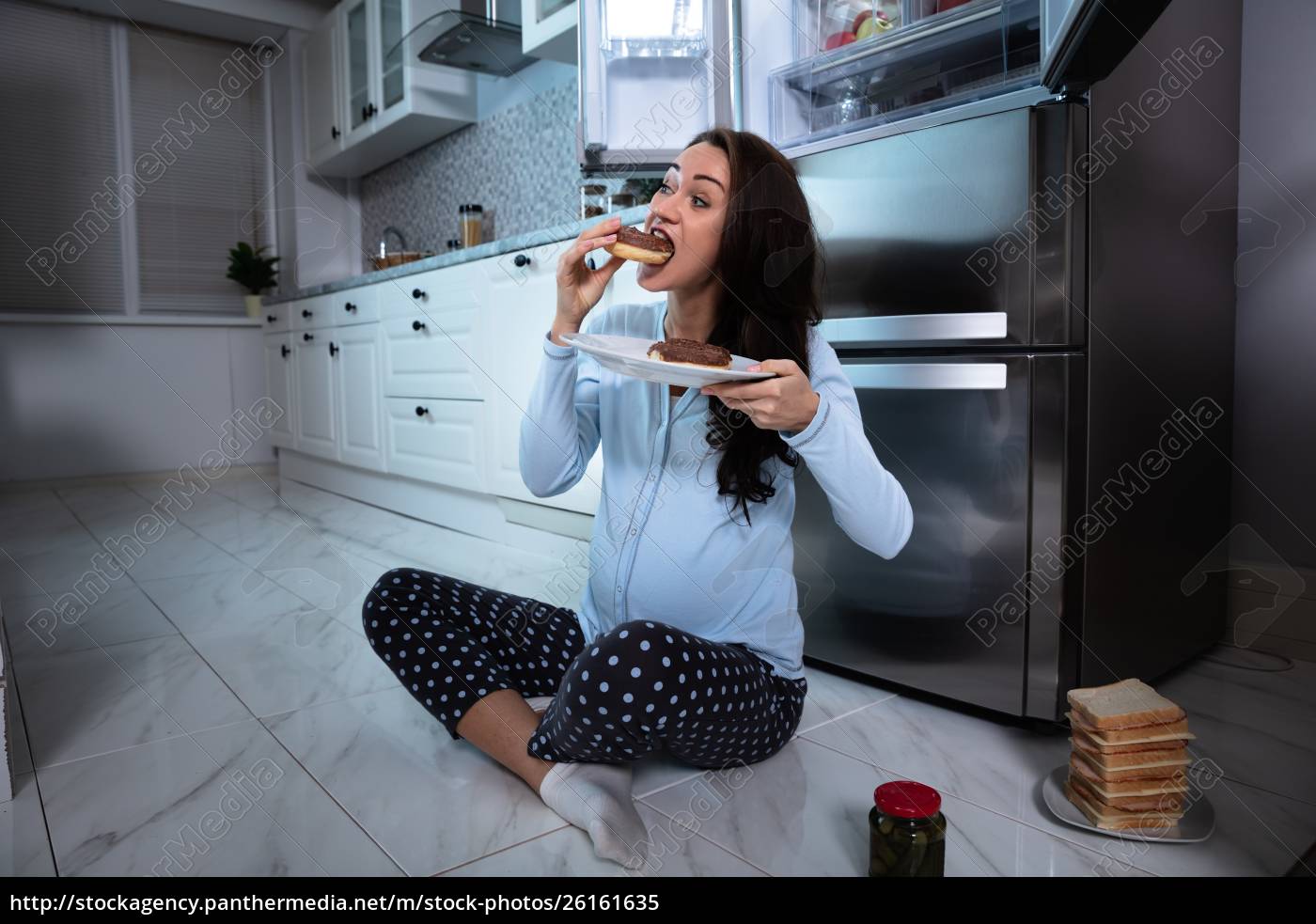 Mulher faminta comendo comida na cozinha - Stockphoto #26161635 | Banco de  Imagens Panthermedia