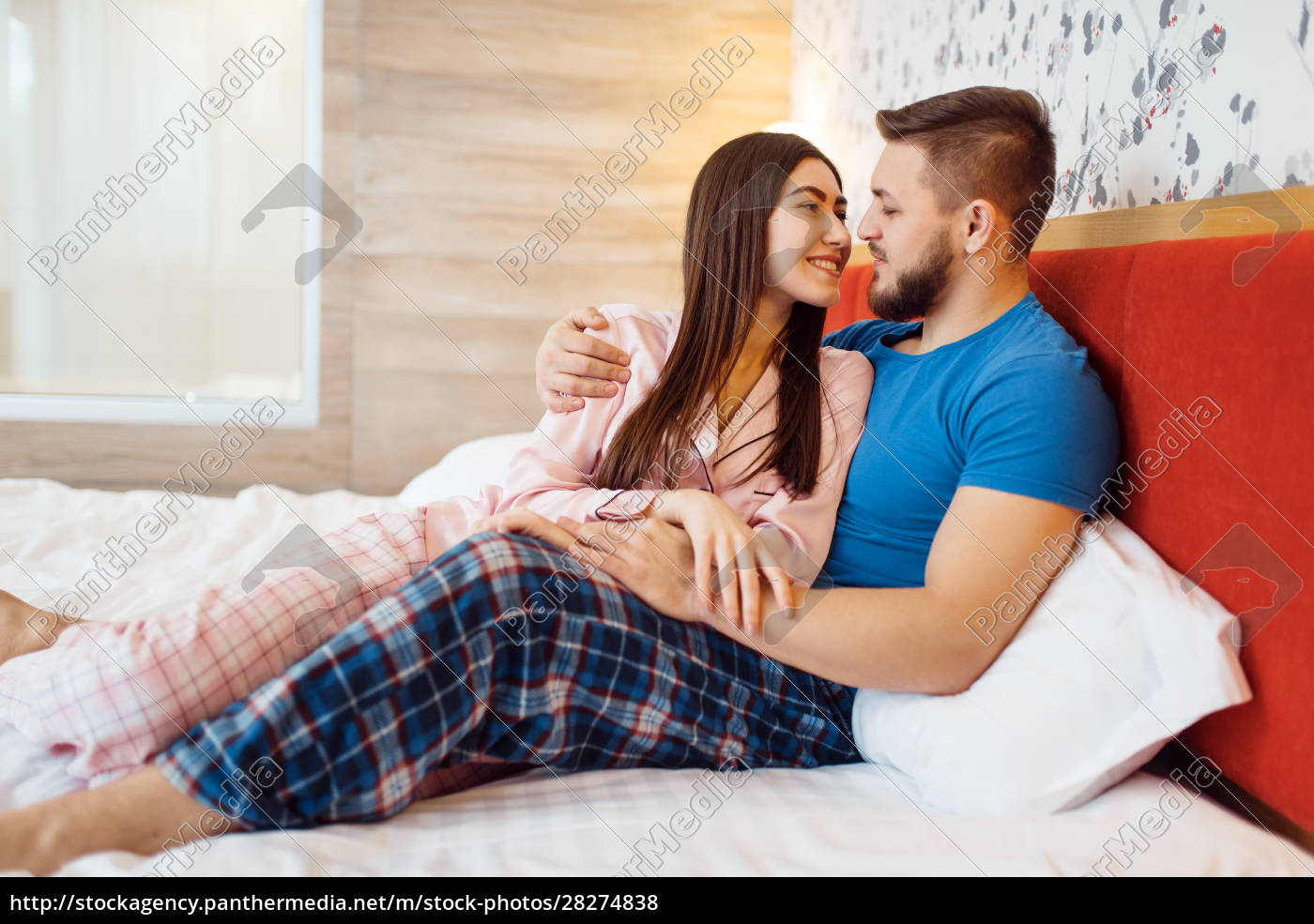 Alegre pareja de amor en pijama abrazos en la cama - Stockphoto #28274838 |  Agencia de stock PantherMedia